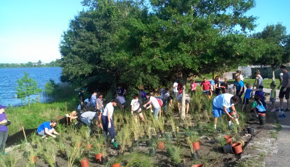 Volunteers planting near a lake