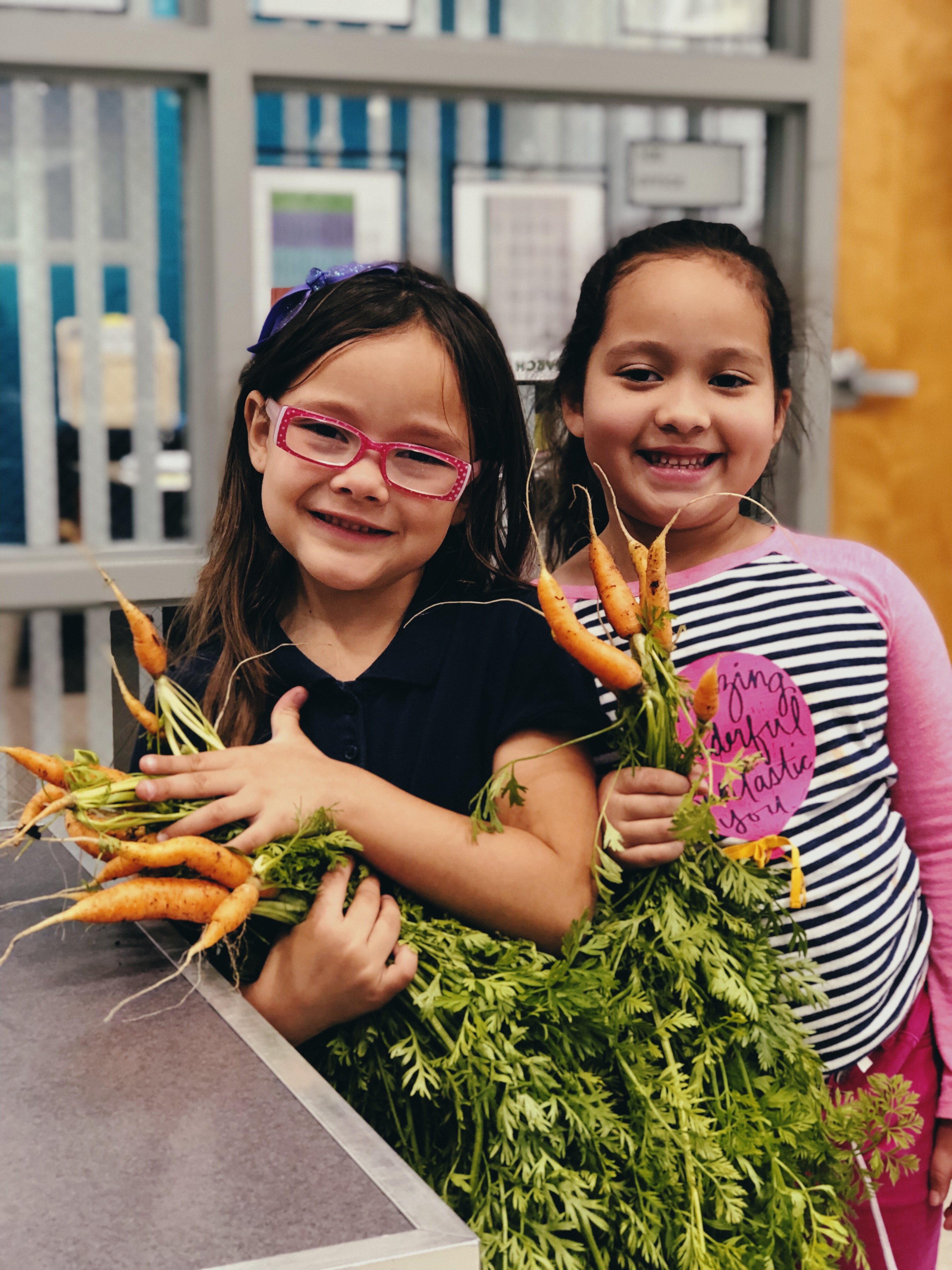 Students showing carrots from their garden activity.