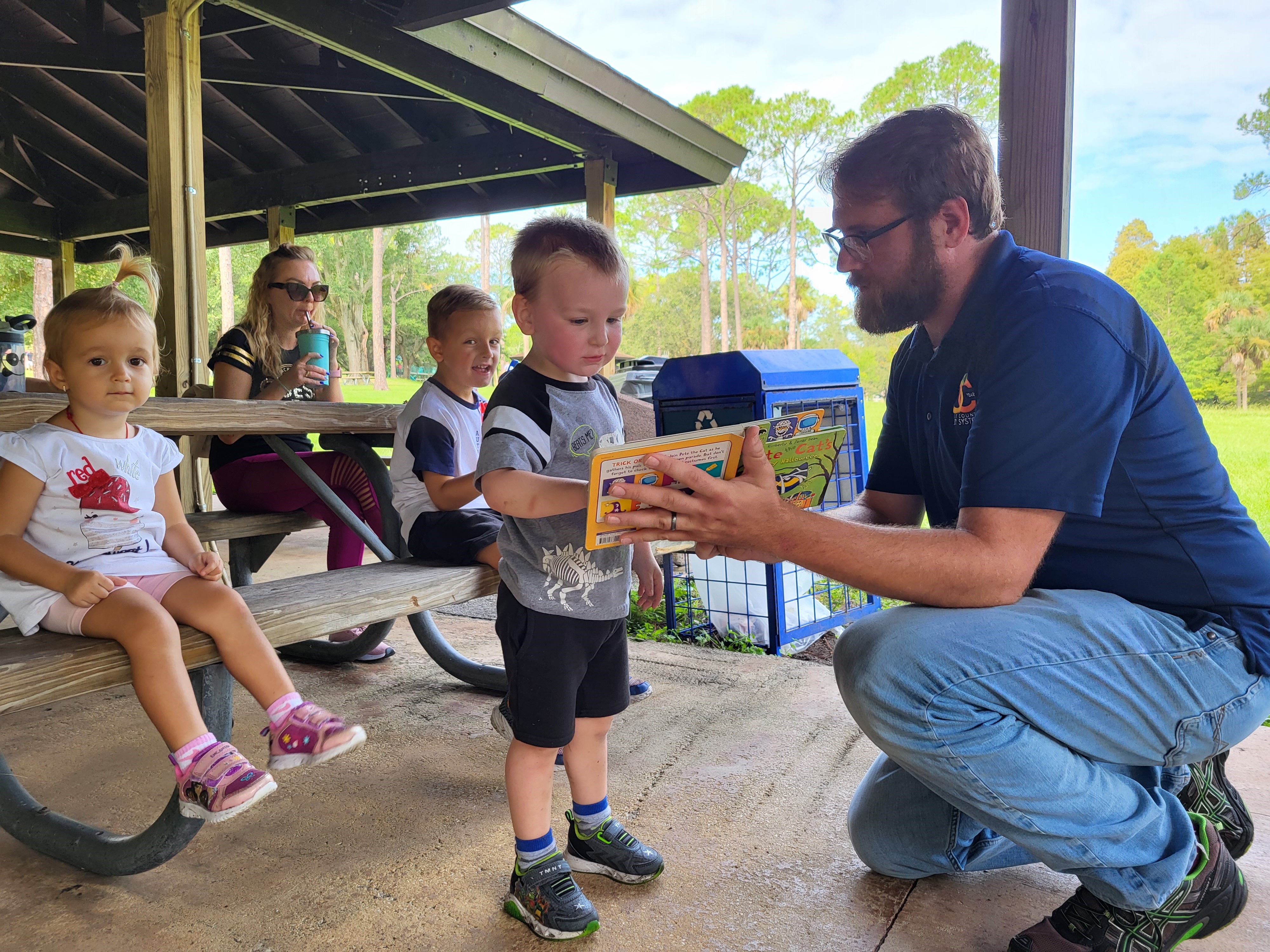 A park ranger reading to children during Storytime at Bill Frederick Park