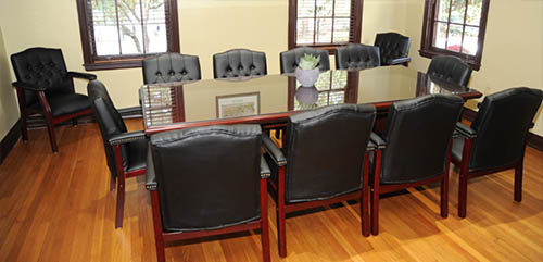 Thorton Park room setup for a meeting with black leather executive chairs around a long table.