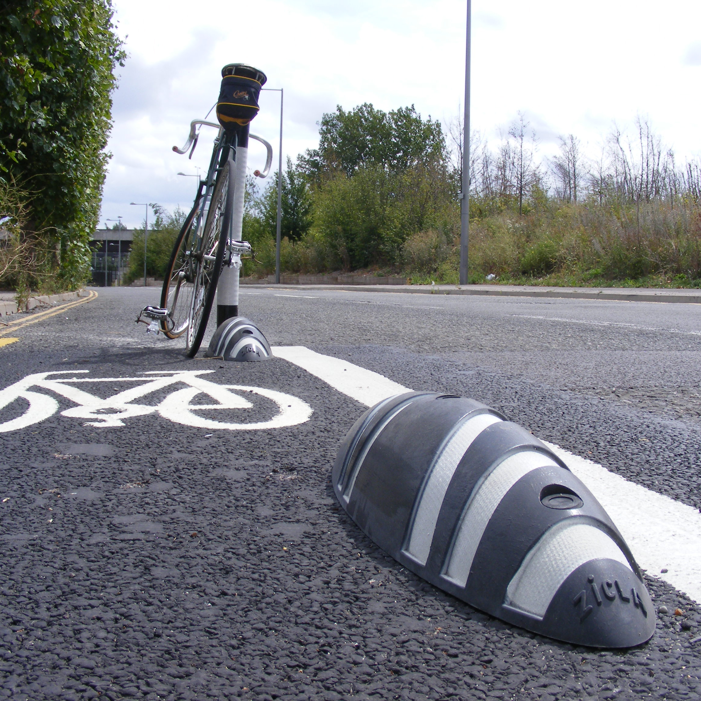 A photograph of a quick-build bicycle lane delineated by striping and low-profile traffic separators.