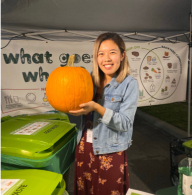 Woman with pumpkin to throw away in compost bin