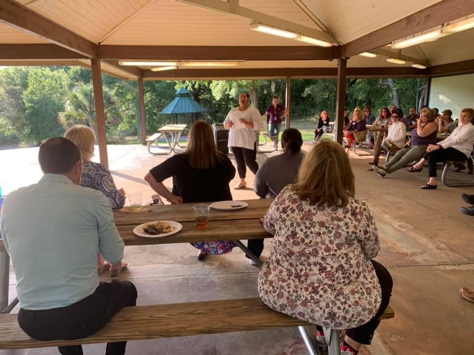 Neighborhood leader teaching neighborhood leaders outside. 