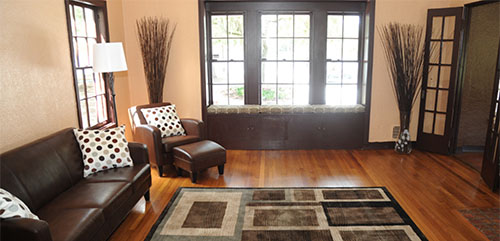 Living room at Eola House featuring a wood floor and brown leather furniture.