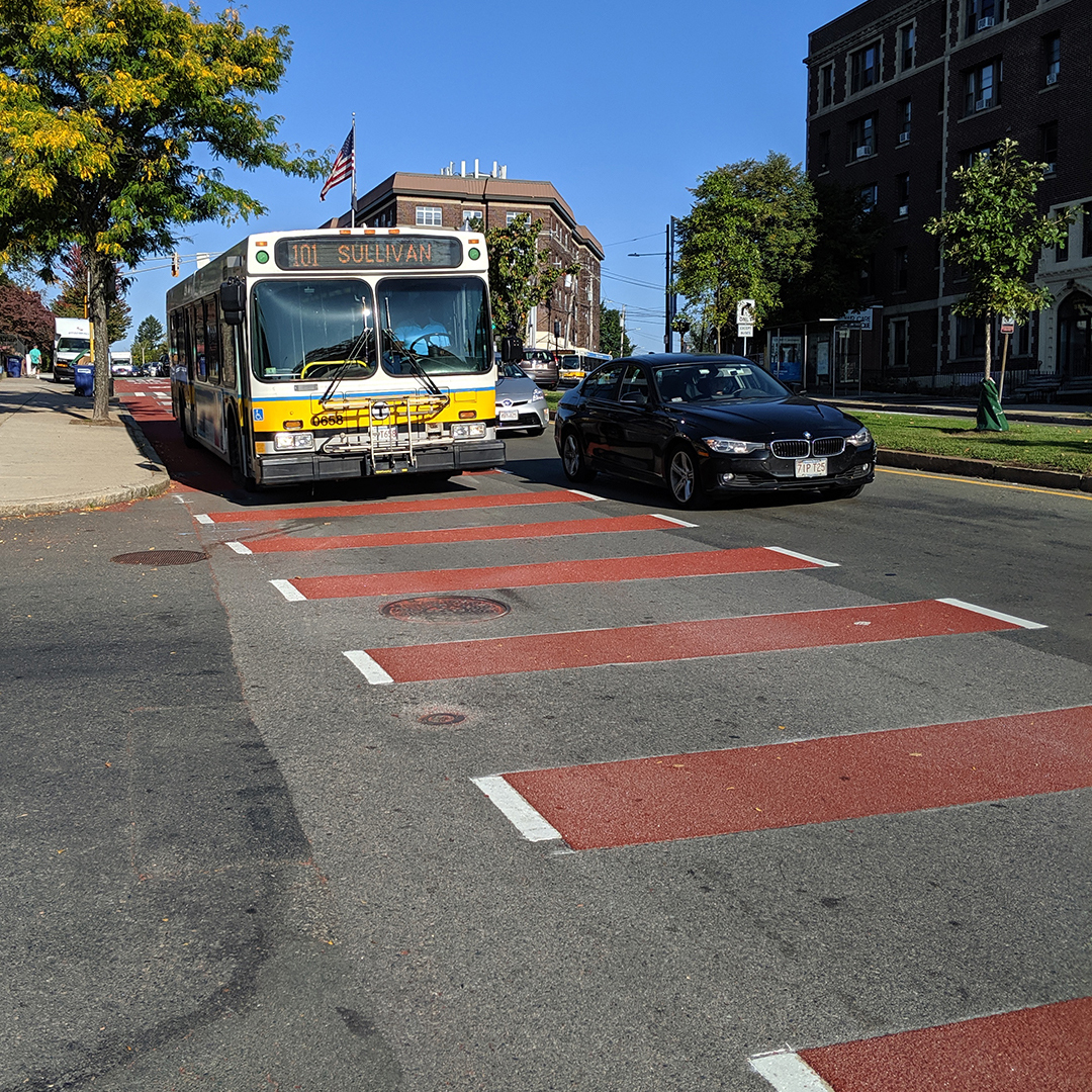 A photograph of a bus-only lane with red markings applied with epoxy gravel.