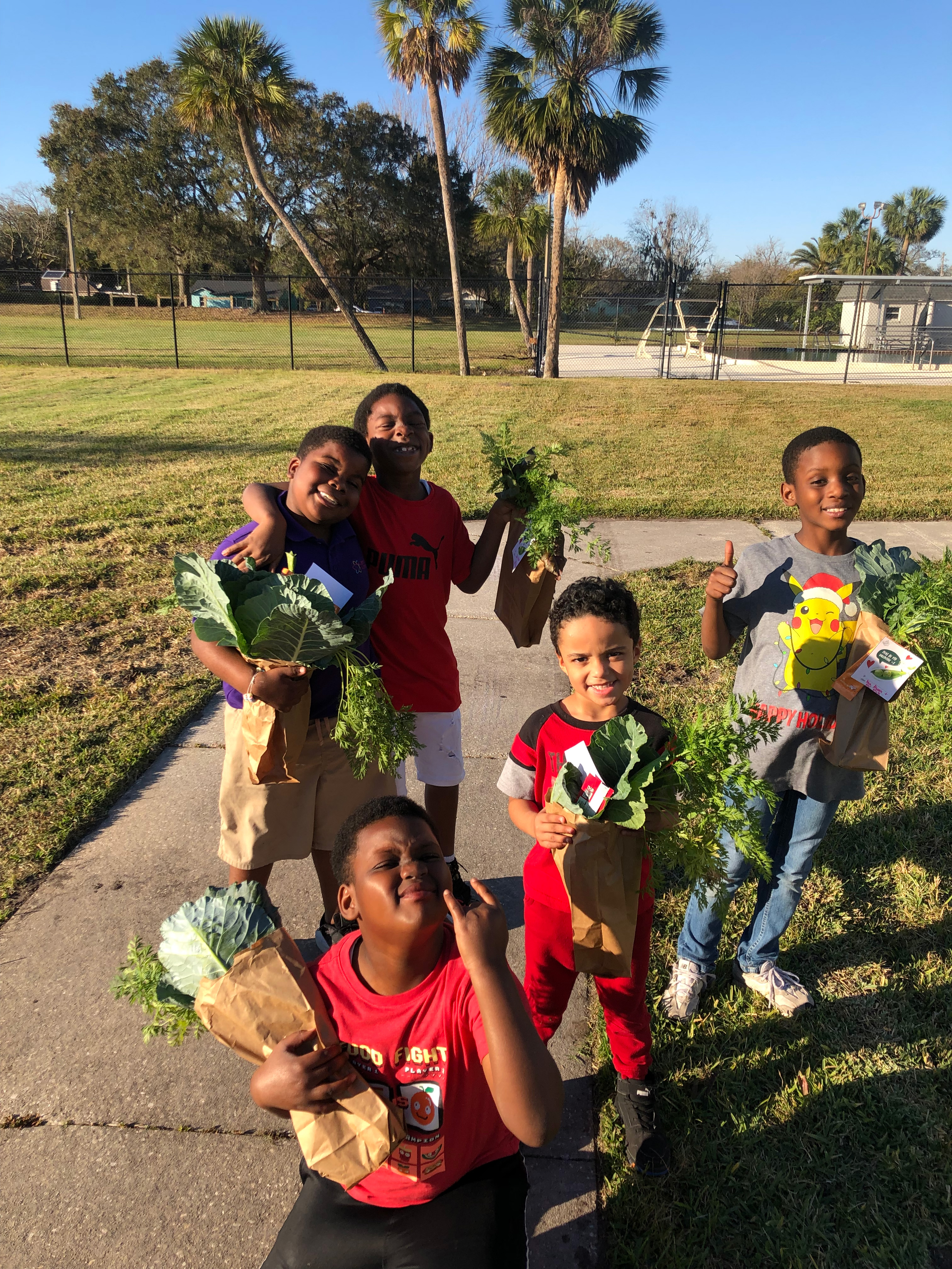 Students holding greens collected from the garden